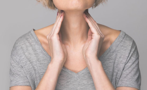 woman checking her thyroid gland