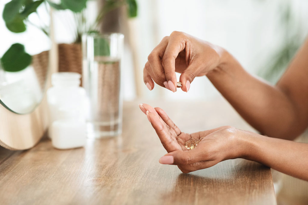 Women's hands taking vitamins