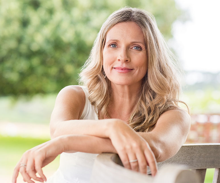 happy menopausal woman sitting on bench