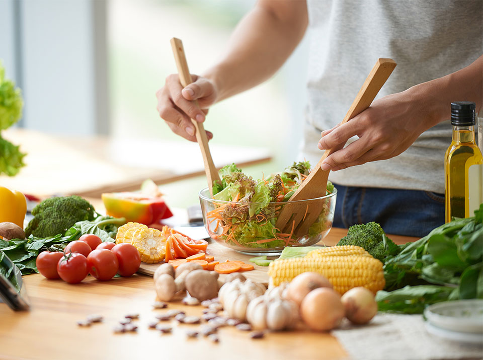 Person mixing a salad in a bowl